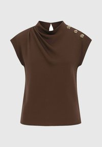Blouse sans manches beige avec un décolleté drapé et trois boutons décoratifs dorés sur une épaule.