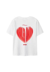 Camiseta blanca con un diseño de corazón distorsionado rojo y el texto "VERSIÓN 2.0" arriba y "CPNHGN" debajo de la forma del corazón.