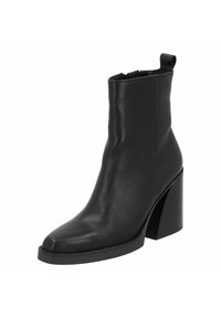 Botín de cuero negro hasta el tobillo con punta afilada y un tacón grueso y alto. Textura suave, diseño minimalista y una lengüeta en la parte posterior.