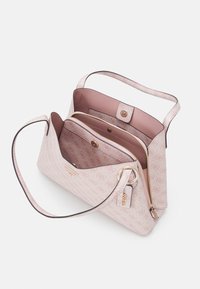 Ljust rosa handväska med ett mönstrat yttre, justerbar rem och gulddetaljer. Har dragkedjeförsedda och knäppta fack inuti.