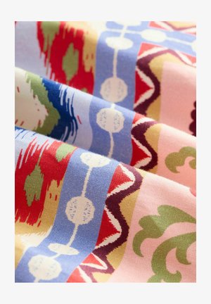 Multicolored fabric features a repeating pattern of circles, waves, and organic shapes in red, blue, green, yellow, and pink hues.
