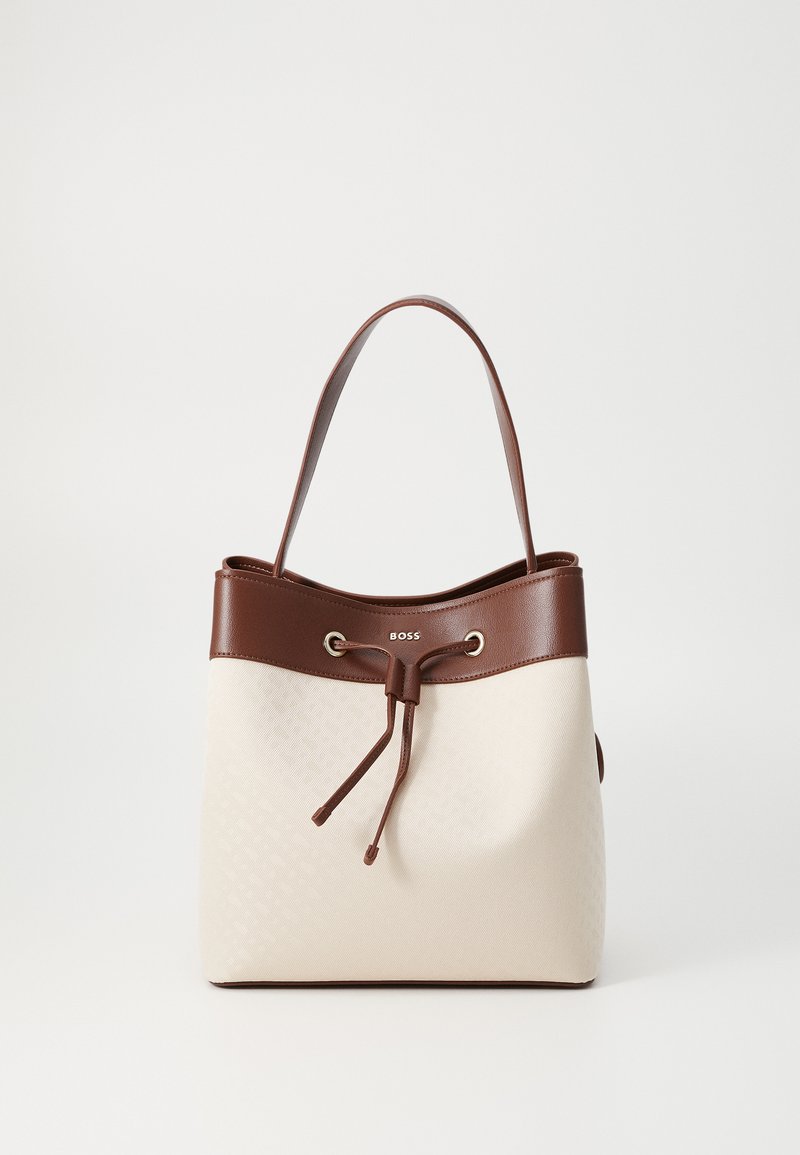 Borsa a secchiello in tela beige con parte superiore in pelle marrone, chiusura a coulisse e dettagli con logo. Caratterizzata da una sola tracolla per il trasporto.