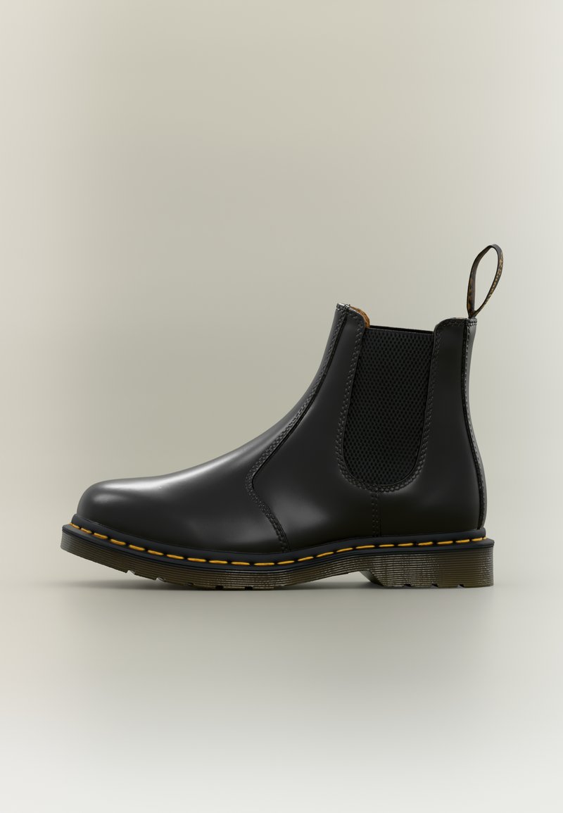 Bota Chelsea preta em couro com painéis laterais elásticos, costura amarela e sola de borracha texturizada. Possui uma aba para puxar na parte de trás.