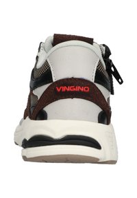 Vista trasera de una zapatilla con un diseño blanco y marrón, material de malla y ante, acentos negros y un logo rojo de "VINGINO".