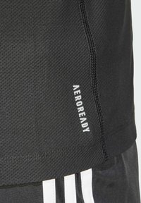 Mustat urheilushortsit, jotka on valmistettu teksturoidusta kankaasta. Niissä on valkoinen "AEROREADY" -logo ja valkoiset sivuviivat.