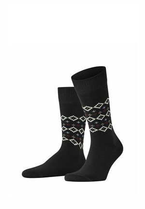 Ein Paar schwarze Crew-Socken mit weißen und roten geometrischen Diamantmustern rund um den Wadenbereich.