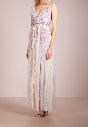 Woman wearing a sleeveless, floor-length lavender gown with ruffles, sequin leopard print bodice, and layered tulle skirt with floral appliqués.