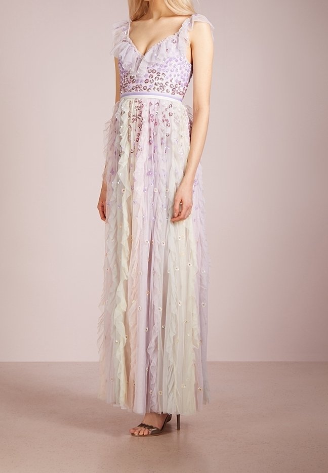 Femme portant une robe lavande sans manches, longue jusqu'au sol, avec volants, un corsage à imprimé léopard pailleté, et une jupe en tulle à plusieurs couches ornée d'appliqués floraux.
