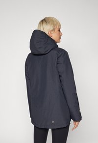 Navy blue waterproof jacket with a hood, featuring a straight cut, elastic cuffs, and minimalistic design. Slightly longer at the back.