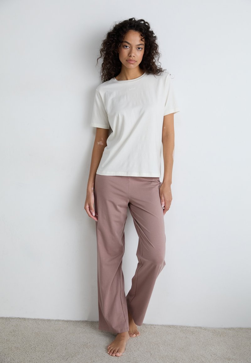 Cream short-sleeve t-shirt paired with pink wide-leg pants. Plain design, soft texture, relaxed fit, and no visible patterns or embellishments.