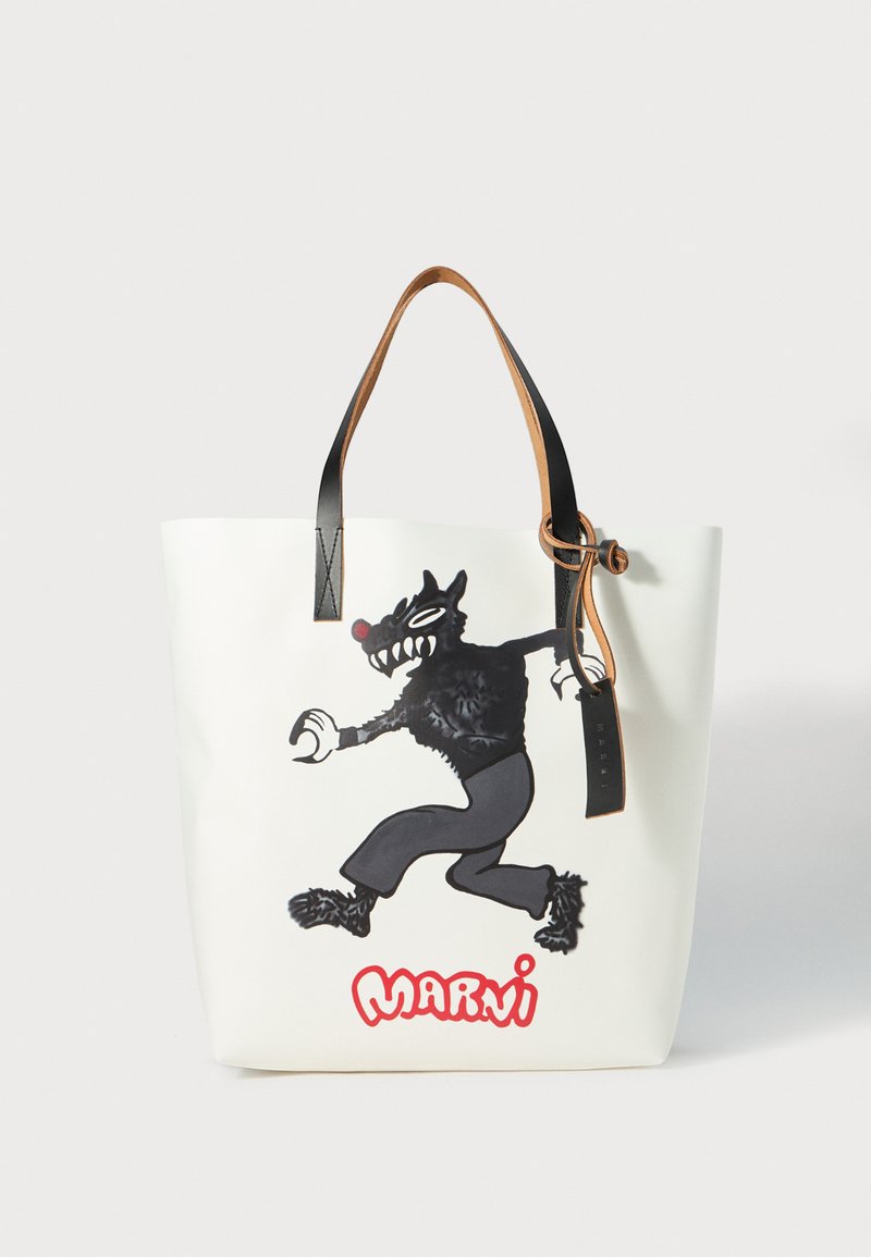 Balta tote soma ar melnu karikatūras vilka grafiku. Ādas rokturi brūnā un melnā krāsā ar mezglu detaļu. Sarkans "MARNI" teksts apakšā.
