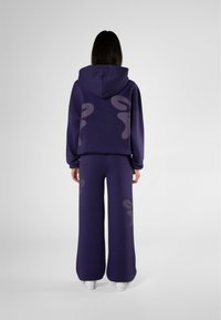 Felpa viola e pantaloni a gamba larga abbinati realizzati in tessuto morbido, con grandi e lisci motivi astratti grigio chiaro sul retro.