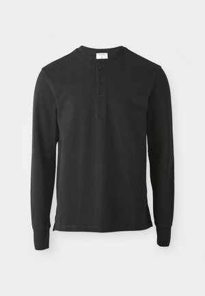Maglietta henley nera a maniche lunghe in cotone, con scollatura rotonda, patta a tre bottoni e polsini aderenti. Tessuto semplice e liscio.