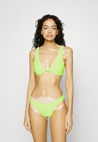 Neon groene bikini-set met een driehoekige bralette met brede bandjes en bijpassende low-rise slipjes, gemaakt van een gladde, rekbare stof.