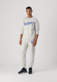 Grauer Sweatshirt mit "Los Angeles" und Logo in Blau, kombiniert mit passenden grauen Jogginghosen. Mit gerippten Bündchen und Saum. Schwarze Laufschuhe.