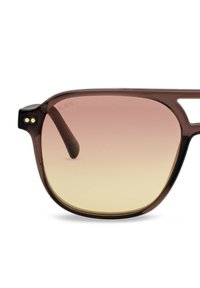 Bruine doorschijnende zonnebril met een rechthoekig montuur en gradientlenzen die overgaan van roze naar lichtgeel.