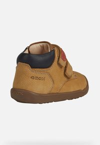 Stivali ankle in pelle marrone con finitura testurizzata, con tacco blu e una fascia in Velcro rossa. Inclusa una suola in gomma marrone e dettagli con logo.