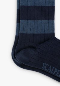Calcetines a rayas azul marino con franjas alternas oscuras y claras, textura acanalada y una banda con el logo "SCALPER" en el tobillo.