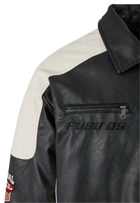 Veste en cuir noir avec accents en cuir crème sur les épaules, poche poitrine zippée et détail embossé "FUBU 05" à l'avant.