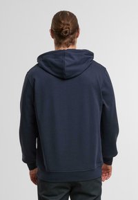Donkerblauwe hoodie met een trekkoordcapuchon, ribgebreide manchetten en zoom. Gladde stofstructuur, ontspannen pasvorm en geen zichtbare logo's of patronen.