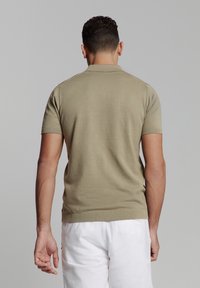 Khaki korte mouw polo shirt met een ribgebreide kraag en manchetten, met een slim fit ontwerp en een gladde textuur. Draag het met witte broeken.