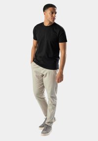 Sort bomulds T-shirt med korte ærmer, parret med beige chinos og grå sneakers. Sættet har et enkelt, klassisk design.