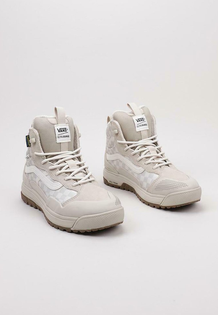 Beige high-top Vans sneakers met een ontwerp van mesh en suede, een tekstuurrubber zool en een opvallend logo op de tong.