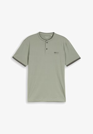 Tricou Henley cu mâneci scurte, verde deschis, cu doi nasturi închiși, margini închise la manșete și inscripția "19/62" pe piept.