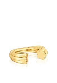Anillo en tono dorado con un diseño ondulado y contorneado, presentado con un acento floral en un extremo, incrustado con piedras rosas para detalle.