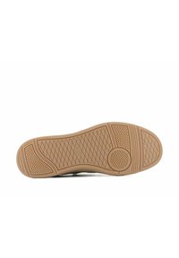 Kengän pohja, jossa on teksturoitu kumipinta, beige väri ja kuvioidut urat pidon ja otteen parantamiseksi.