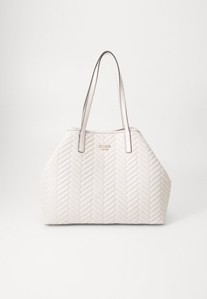 Borsa a tracolla beige trapuntata con un motivo a spina di pesce, dotata di due manici lunghi e un logo dorato come accentuazione. Texture liscia e forma angolare.