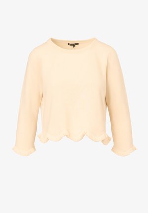 Light beige cropped sweatshirt with a round neckline, three-quarter sleeves, and wavy fringe hemline. Soft fabric with a smooth texture.