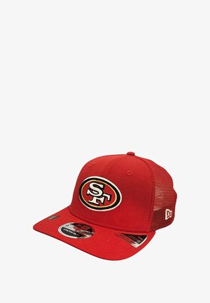 Rote Baseballmütze aus Stoff mit Netzrücken, mit einem bestickten "SF"-Logo innerhalb eines Ovals auf der Vorderseite und mehreren Etikettenaufklebern daran.