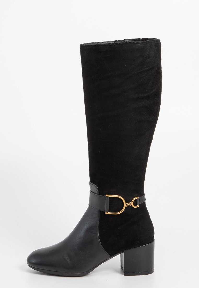 Botte noire montée jusqu'au genou en combinaison de daim et de cuir, avec un talon épais et un accent en boucle dorée sur une sangle en cuir.