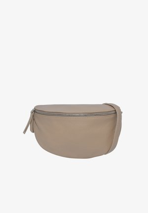 Jeune femme portant un haut noir à manches longues et un pantalon noir, avec un grand sac porté en bandoulière en cuir taupe avec une fermeture éclair argentée.