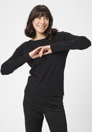 Juodas megztinis su apvalia iškirpte ir ilgomis rankovėmis, papuoštas mažais blizgučiais ant kūno ir pečių.
