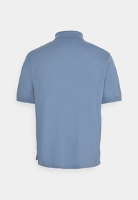 Blå pikétröja med krage och korta ärmar, tillverkad av ett mjukt och slätt tyg. Har en rak nederkant och diskret sömnad.