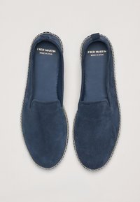 Zapatos de ante azul oscuro sin cordones con un acabado texturizado, que presentan un contraste de costura de color claro a lo largo del borde y un interior suave.
