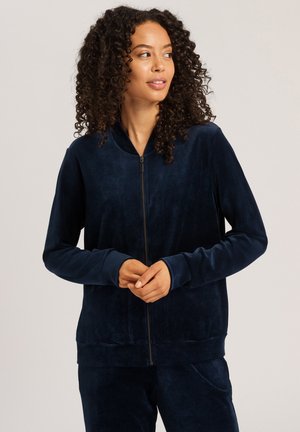 Marineblauwe rits-hoodie van zachte, gestructureerde stof met lange mouwen en geribde manchetten, met een eenvoudig ontwerp en een lage kraag.