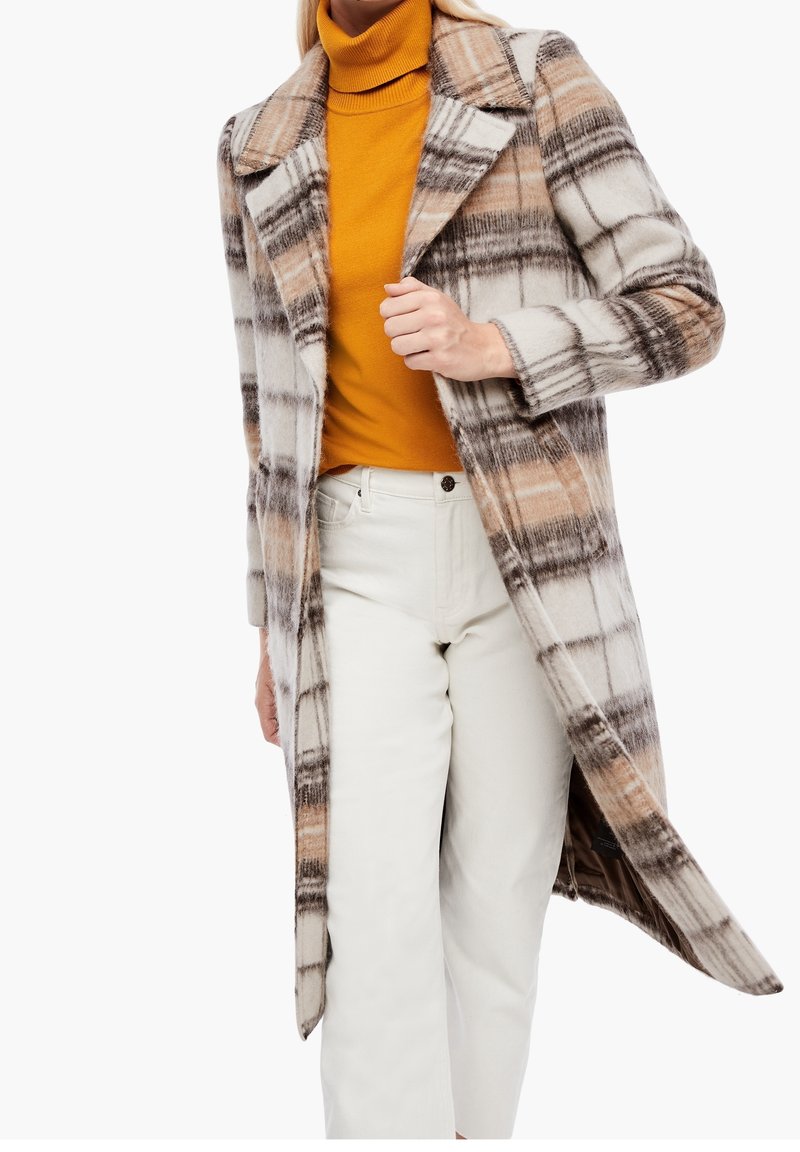 Abrigo de cuadros en tonos beige, marrón y blanco, con mangas largas, cuello con muesca y abertura frontal, superpuesto a un cuello alto mostaza.