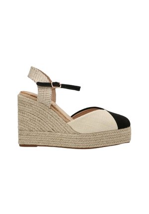 Sandalias de cuña con punta en negro y beige, suela de yute trenzado, correa ajustable en el tobillo y parte superior de tejido texturizado.