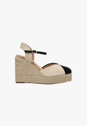 Sandalias de cuña con punta en negro y beige, suela de yute trenzado, correa ajustable en el tobillo y parte superior de tejido texturizado.
