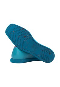 Scarpa slip-on blu con tomaia in pelle liscia, suola in gomma testurizzata con dettagli maculati e elementi di design minimalisti.