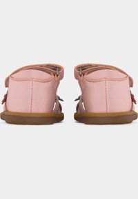 Ροζ σανδάλια για νήπια με καφέ σόλες, κλειστές φτέρνες, ρυθμιζόμενα λουράκια στον αστράγαλο, ορατές ραφές, εμφανιζόμενα από πίσω σε απλό φόντο.
