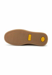 Suela de zapato de goma en color beige con un patrón texturizado y estriado. Presenta un detalle de logotipo amarillo y un acento circular en el talón.