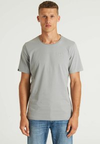 Grijze T-shirt met korte mouwen en een ronde hals, gemaakt van zacht materiaal, met een klein geborduurd vierkant logo op de borst.