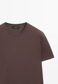 Brun bomulds-T-shirt med rund hals, korte ærmer og en glat tekstur. Inde i t-shirten er der en mærkat med "Massimo Dutti"-branding.