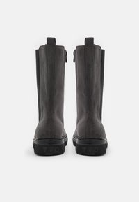 Black suede ankle boots with elastic side panels, a smooth finish, and embossed logo on the heel; features a durable rubber sole.