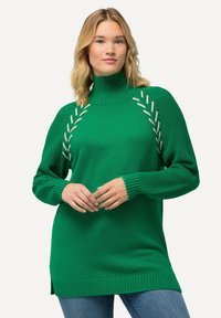 Maglione verde lavorato a maglia con collo alto, caratterizzato da dettagli intrecciati vicino alle spalle e polsini a costine. Il design include spacco laterale sull'orlo.