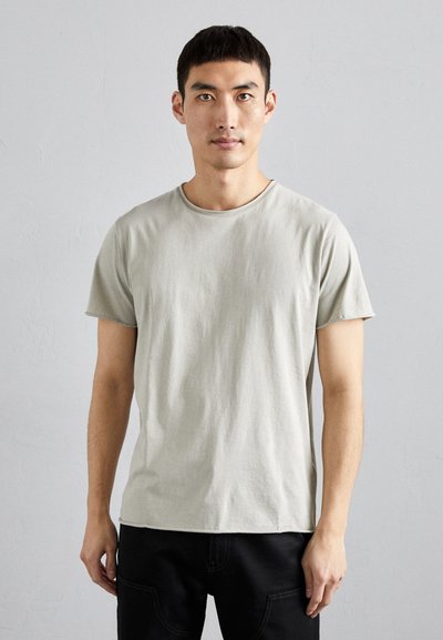 T-shirt grigia chiara a maniche corte con colletto rotondo, realizzata in morbido tessuto, con una vestibilità rilassata e una leggera trama.